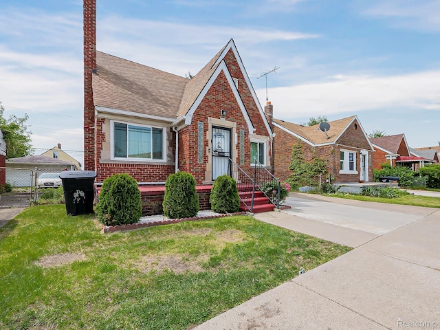 3878 Charles St, Hamtramck, MI 48212 - english style home featuring brick siding, a chimney, and roof with shingles