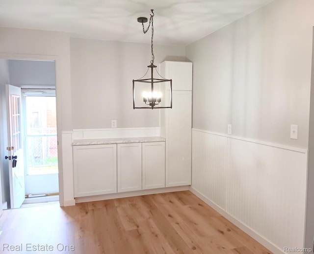 2809 Sparta Dr, Troy, MI 48083 - unfurnished dining area featuring a chandelier, light wood-style floors, and a wainscoted wall