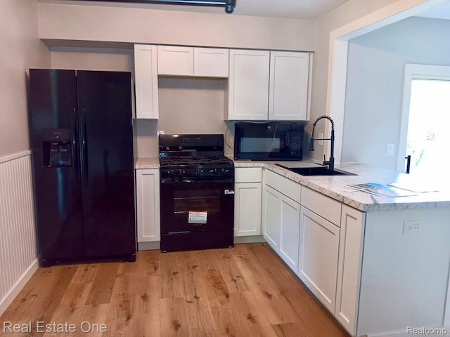 2809 Sparta Dr, Troy, MI 48083 - kitchen with black appliances, a sink, white cabinets, and a peninsula