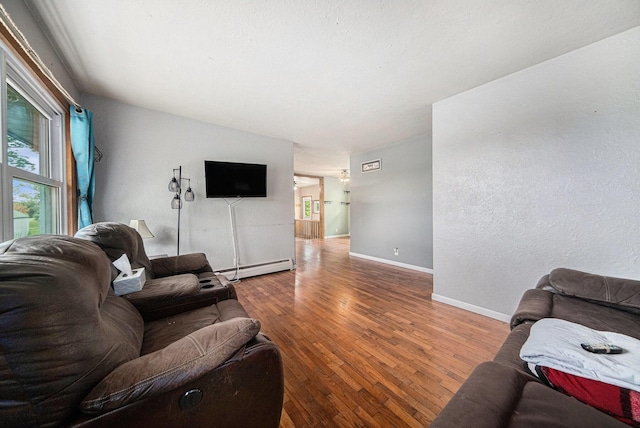 3225 Fishville Rd, Grass Lake, MI 49240 - living room with a baseboard radiator, hardwood / wood-style flooring, and baseboards