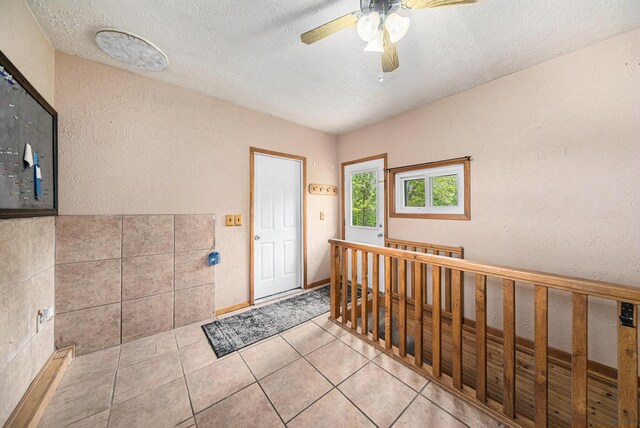 3225 Fishville Rd, Grass Lake, MI 49240 - foyer featuring a textured wall, a textured ceiling, a ceiling fan, and light tile patterned floors