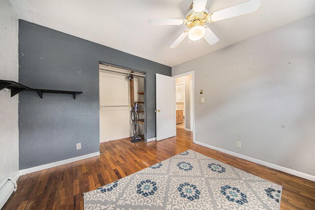 3225 Fishville Rd, Grass Lake, MI 49240 - bedroom with baseboard heating, wood finished floors, baseboards, a ceiling fan, and a closet