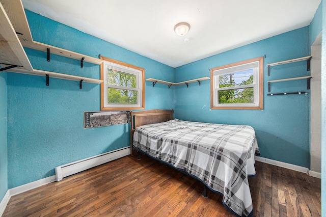 3225 Fishville Rd, Grass Lake, MI 49240 - bedroom featuring a baseboard radiator, baseboards, wood finished floors, and a textured wall