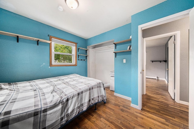3225 Fishville Rd, Grass Lake, MI 49240 - bedroom featuring baseboard heating, wood finished floors, baseboards, a textured wall, and a closet