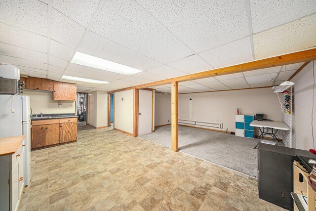 3225 Fishville Rd, Grass Lake, MI 49240 - kitchen featuring freestanding refrigerator, a baseboard radiator, open floor plan, a paneled ceiling, and brown cabinets