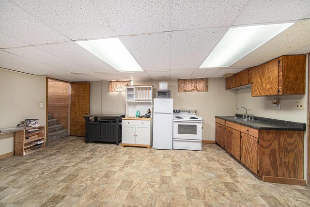 3225 Fishville Rd, Grass Lake, MI 49240 - kitchen featuring white appliances, a sink, a paneled ceiling, brown cabinets, and dark countertops