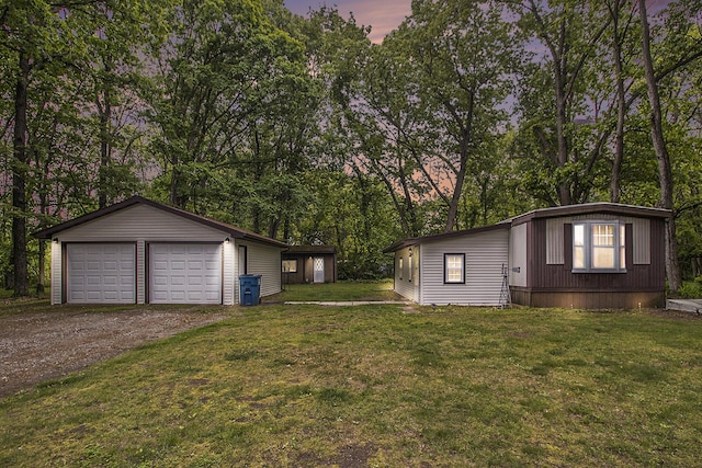 24923 Sandy Beach Dr, Edwardsburg, MI 49112 - view of side of home featuring an outdoor structure, a detached garage, a lawn, and view of wooded area