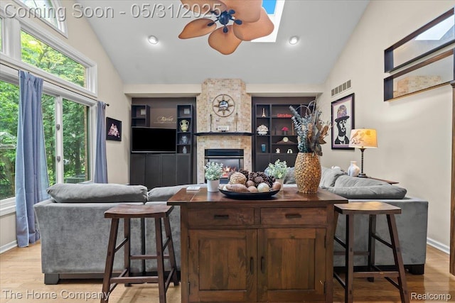 5182 Shady Creek Dr, Troy, MI 48085 - living room with light wood-type flooring, a fireplace, a ceiling fan, baseboards, and high vaulted ceiling