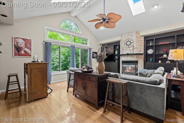 5182 Shady Creek Dr, Troy, MI 48085 - living area with a large fireplace, light wood-style floors, a skylight, beam ceiling, and ceiling fan
