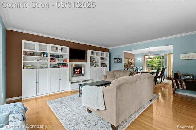 5182 Shady Creek Dr, Troy, MI 48085 - living area featuring crown molding, light wood-style floors, a lit fireplace, and a chandelier