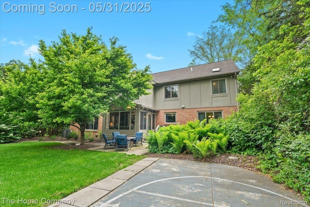 5182 Shady Creek Dr, Troy, MI 48085 - rear view of property featuring brick siding, a lawn, a patio, and a sunroom