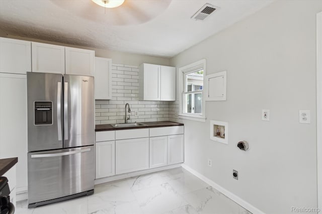 14134 Syracuse St, Southgate, MI 48180 - kitchen with stainless steel fridge with ice dispenser, a sink, dark countertops, white cabinetry, and decorative backsplash