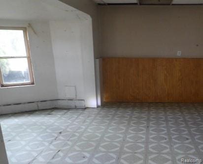 1747 Tennis Ct, Pleasant Lake, MI 49272 - spare room featuring light flooring, wainscoting, a baseboard heating unit, and wood walls