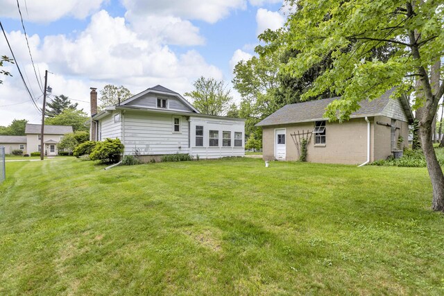 547 Pershing Ave, Jackson, MI 49203 - rear view of property with a lawn and a chimney