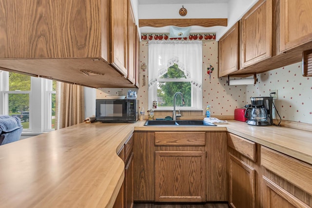 547 Pershing Ave, Jackson, MI 49203 - kitchen featuring black microwave, wallpapered walls, a sink, butcher block counters, and brown cabinetry