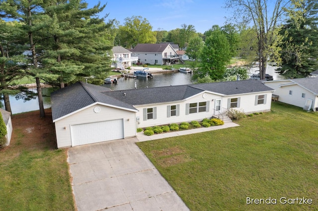17055 Blackfoot Trl, Howard City, MI 49329 - view of front of house featuring a water view, a garage, concrete driveway, and a front lawn
