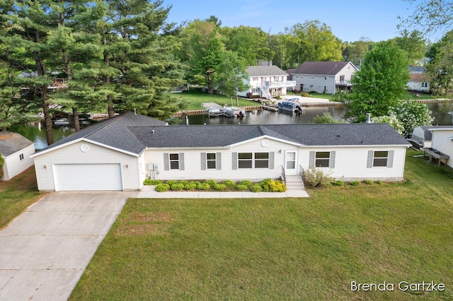 17055 Blackfoot Trl, Howard City, MI 49329 - view of front of house featuring driveway, a water view, an attached garage, and a front yard