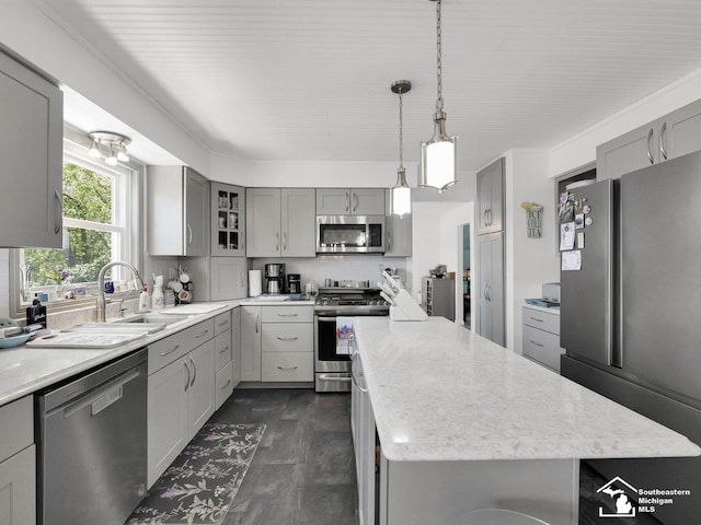 11963 Egan Hwy, Brooklyn, MI 49230 - kitchen featuring appliances with stainless steel finishes, gray cabinets, a center island, and decorative backsplash