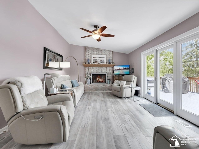 11963 Egan Hwy, Brooklyn, MI 49230 - living area featuring vaulted ceiling, a ceiling fan, light wood-type flooring, and a brick fireplace