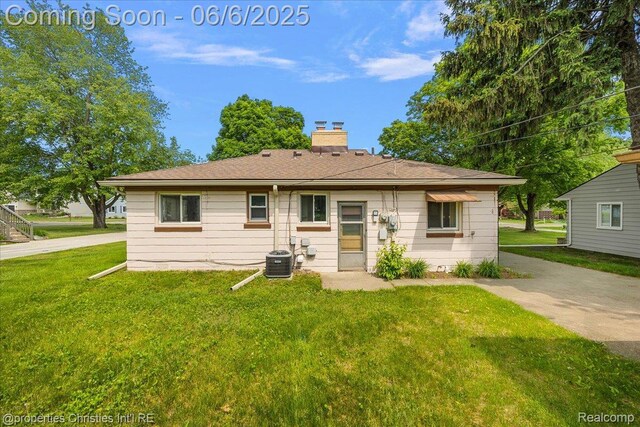 15501 Portis St, Northville, MI 48170 - back of house featuring a chimney, a yard, and central air condition unit