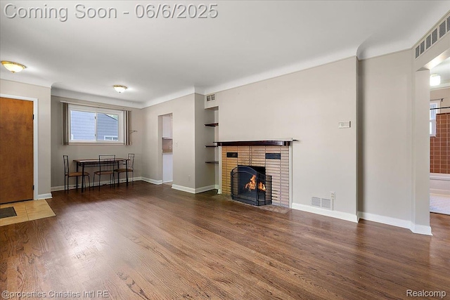 15501 Portis St, Northville, MI 48170 - unfurnished living room featuring wood finished floors, baseboards, a fireplace, and built in shelves