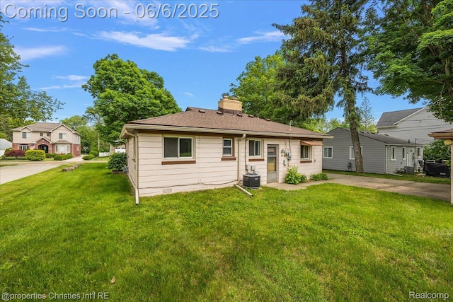 15501 Portis St, Northville, MI 48170 - view of front of house featuring a front yard, a chimney, and cooling unit