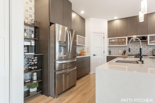 104 River Hills Dr, Holland, MI 49424 - kitchen with stainless steel appliances, modern cabinets, light wood finished floors, tasteful backsplash, and recessed lighting