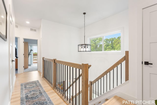 104 River Hills Dr, Holland, MI 49424 - hallway with a chandelier, light wood-type flooring, an upstairs landing, and baseboards