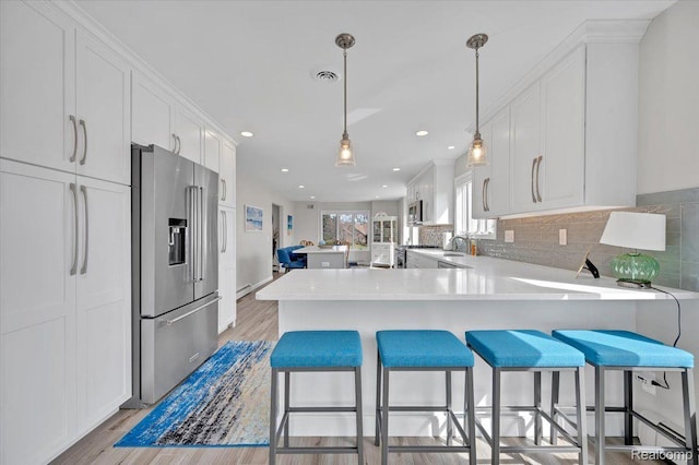 61381 Miriam Dr, Washington, MI 48094 - kitchen with stainless steel appliances, a peninsula, light wood-style flooring, white cabinets, and recessed lighting