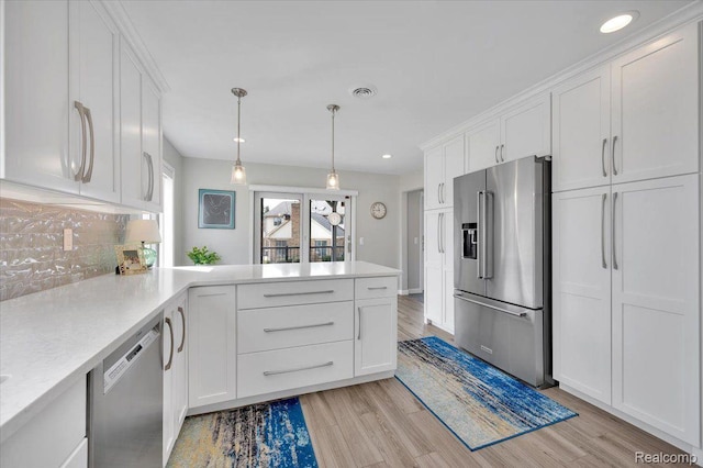 61381 Miriam Dr, Washington, MI 48094 - kitchen with stainless steel appliances, white cabinetry, light countertops, light wood-type flooring, and a peninsula