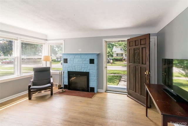 19988 Macarthur St, Redford, MI 48240 - living room featuring light wood-style flooring and a stone fireplace