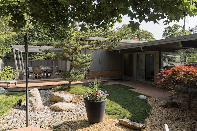 35 Fultonwood Dr SE, Grand Rapids, MI 49503 - back of house featuring a deck, outdoor dining space, a chimney, and brick siding