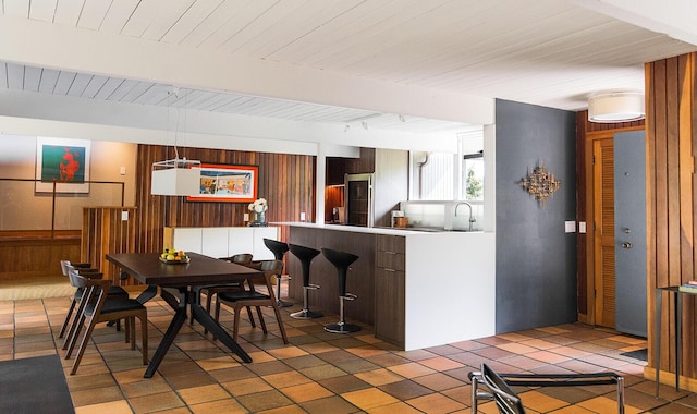35 Fultonwood Dr SE, Grand Rapids, MI 49503 - dining room featuring wooden walls, light tile patterned floors, and wood ceiling with exposed beams