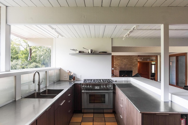 35 Fultonwood Dr SE, Grand Rapids, MI 49503 - kitchen with high end stove, a sink, track lighting, wood ceiling, and a peninsula