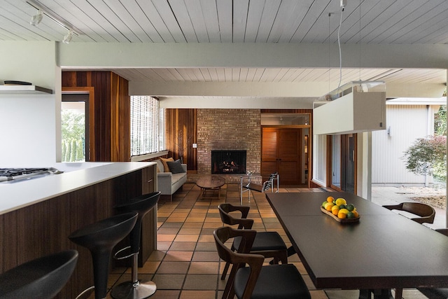 35 Fultonwood Dr SE, Grand Rapids, MI 49503 - tiled dining room featuring wooden ceiling with exposed beams, wood walls, and a fireplace