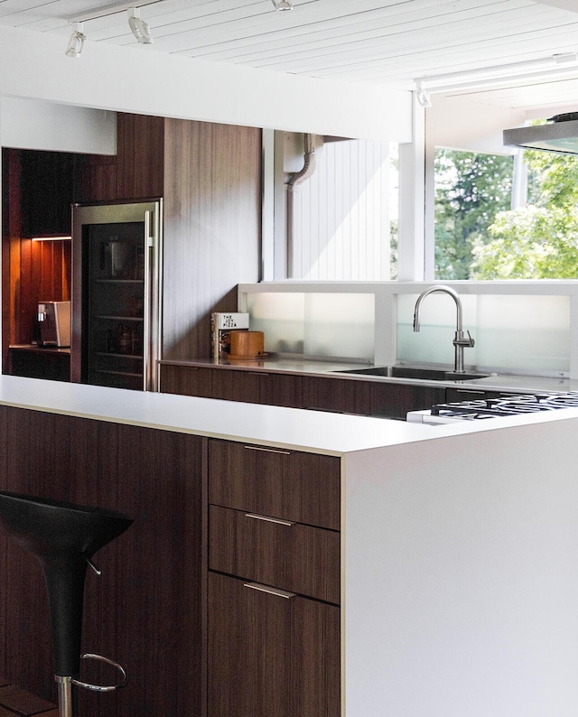 35 Fultonwood Dr SE, Grand Rapids, MI 49503 - kitchen with wine cooler, a sink, modern cabinets, and track lighting
