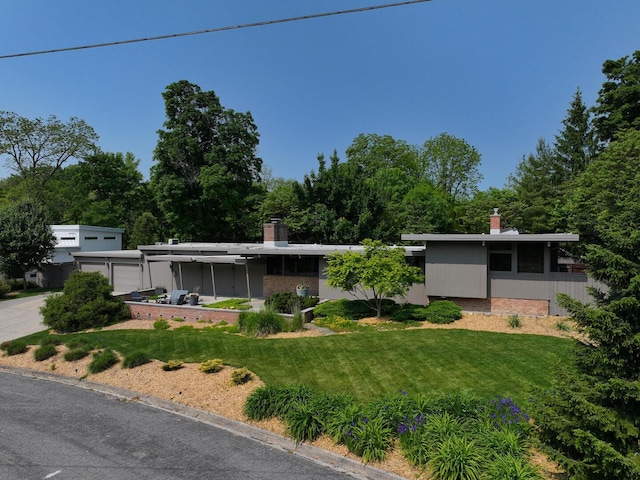 35 Fultonwood Dr SE, Grand Rapids, MI 49503 - view of front facade featuring a front yard, a chimney, driveway, and an attached garage