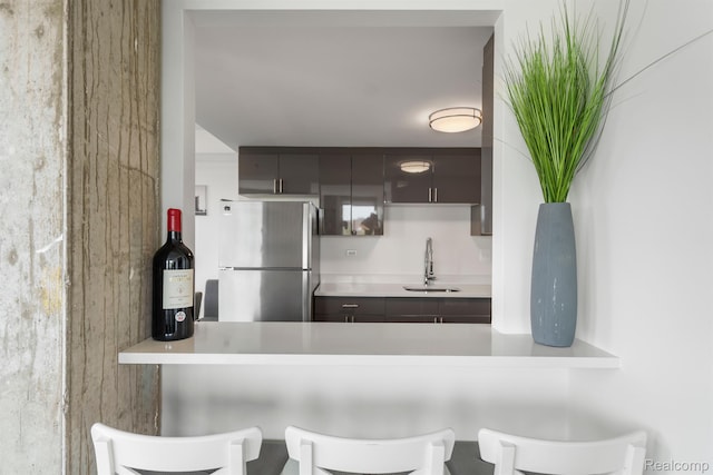 3320 Spinnaker Ln Unit 4A, Detroit, MI 48207 - kitchen featuring freestanding refrigerator, a sink, light countertops, a kitchen breakfast bar, and a peninsula