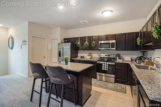 9777 Ridge Run St Unit 67, Howell, MI 48855 - kitchen featuring stainless steel appliances, a sink, a kitchen breakfast bar, a kitchen island, and light wood-style floors