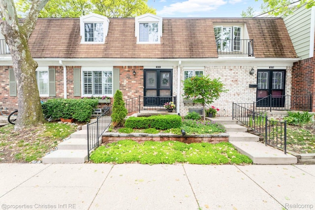 1874 Wickham St Unit 68, Royal Oak, MI 48073 - view of front of house with french doors, mansard roof, brick siding, and a shingled roof