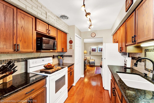 1874 Wickham St Unit 68, Royal Oak, MI 48073 - kitchen with white electric range, black microwave, a sink, brown cabinetry, and tasteful backsplash