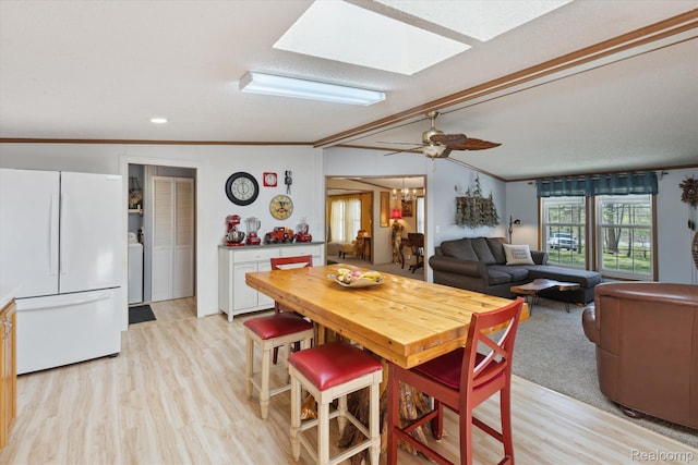 4952 Davison Rd, Lapeer, MI 48446 - dining space with light wood finished floors, a skylight, washer / dryer, and ornamental molding