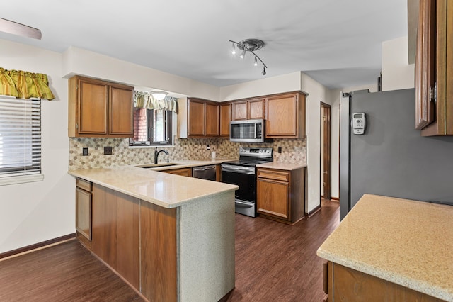3244 Dearborn St, Wayne, MI 48184 - kitchen with stainless steel appliances, a sink, a peninsula, dark wood-type flooring, and decorative backsplash