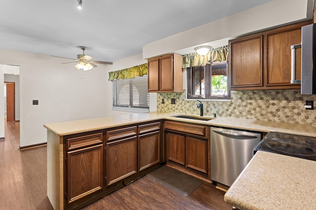 3244 Dearborn St, Wayne, MI 48184 - kitchen featuring stainless steel dishwasher, a sink, a peninsula, dark wood-type flooring, and backsplash