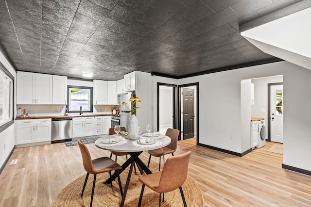 17465 Rapids Dr, Hersey, MI 49639 - dining area featuring light wood-type flooring, washer / clothes dryer, and baseboards
