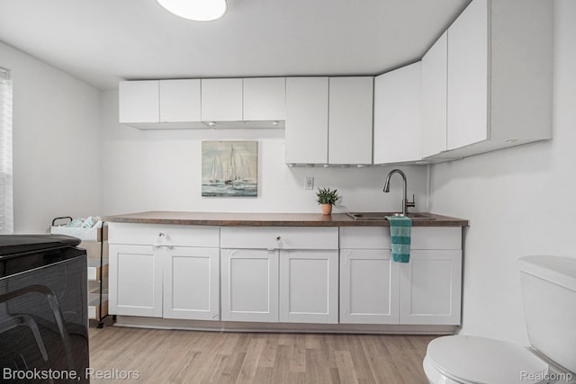 3012 Lansdowne Rd, Waterford, MI 48329 - kitchen with a sink, light wood-type flooring, white cabinets, and dark countertops