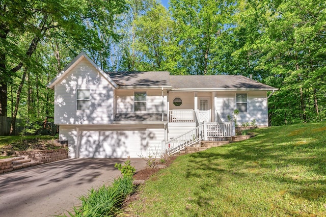 4085 Ravina Ter, Saint Joseph, MI 49085 - view of front of house with an attached garage, asphalt driveway, stairway, a front lawn, and covered porch