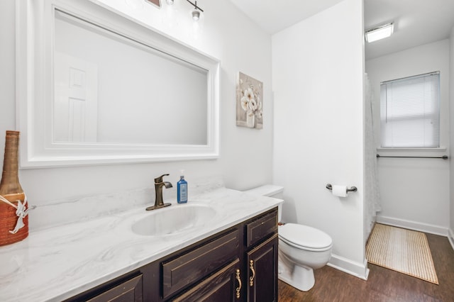 4085 Ravina Ter, Saint Joseph, MI 49085 - bathroom featuring vanity, toilet, wood finished floors, baseboards, and a shower with shower curtain