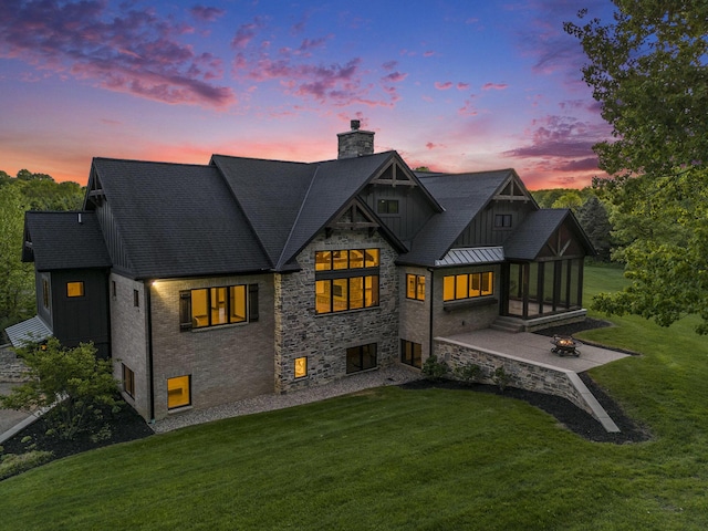 4035 136th Ave, Hamilton, MI 49419 - back of property with a chimney, a patio area, a yard, board and batten siding, and stone siding