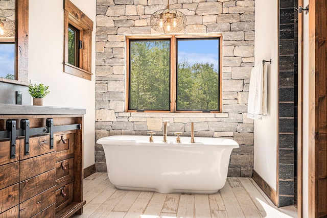 4035 136th Ave, Hamilton, MI 49419 - bathroom featuring a soaking tub, wood finished floors, vanity, and baseboards